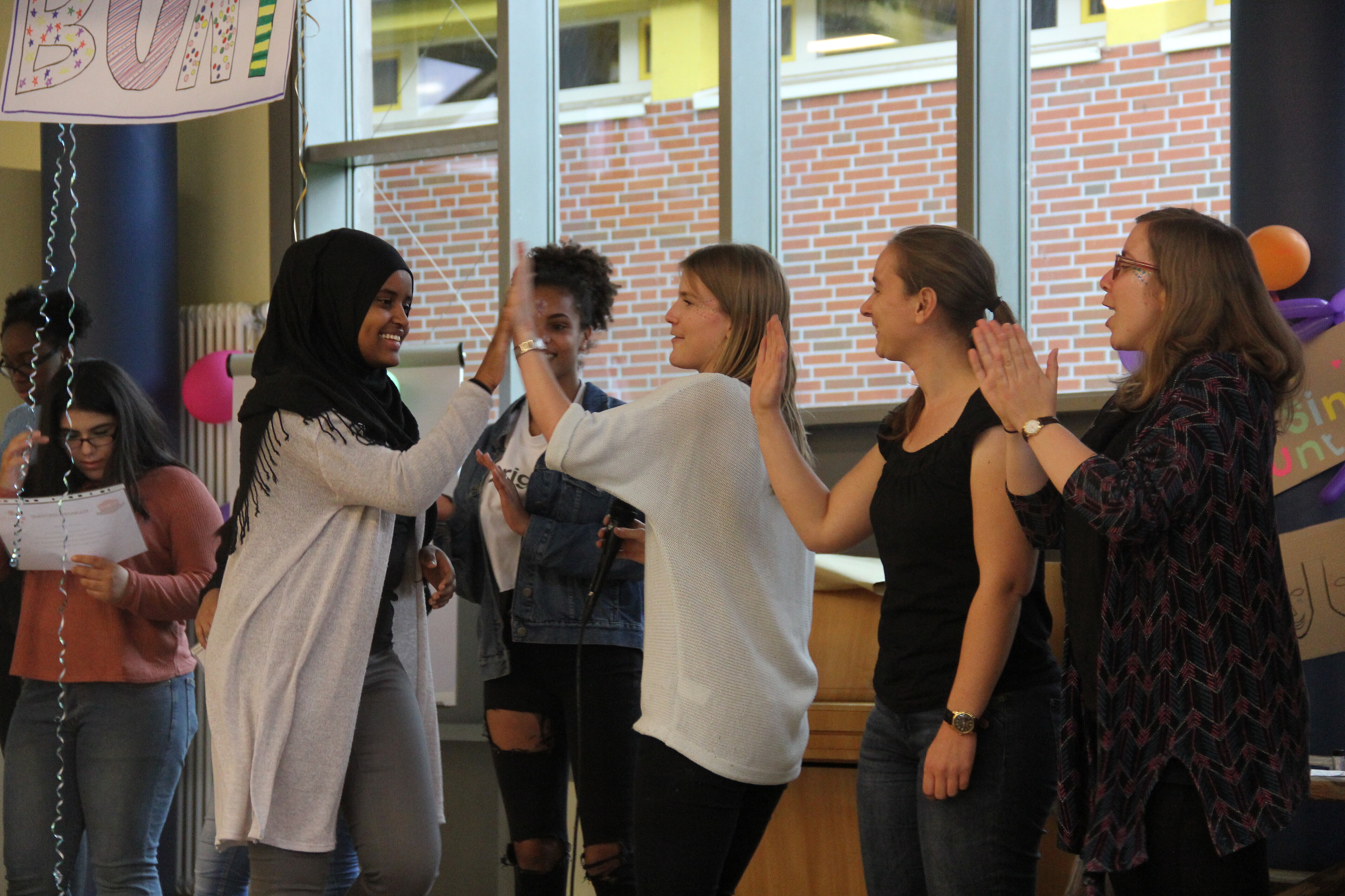 Foto: Fünf Schülerinnen klatschen sich ab