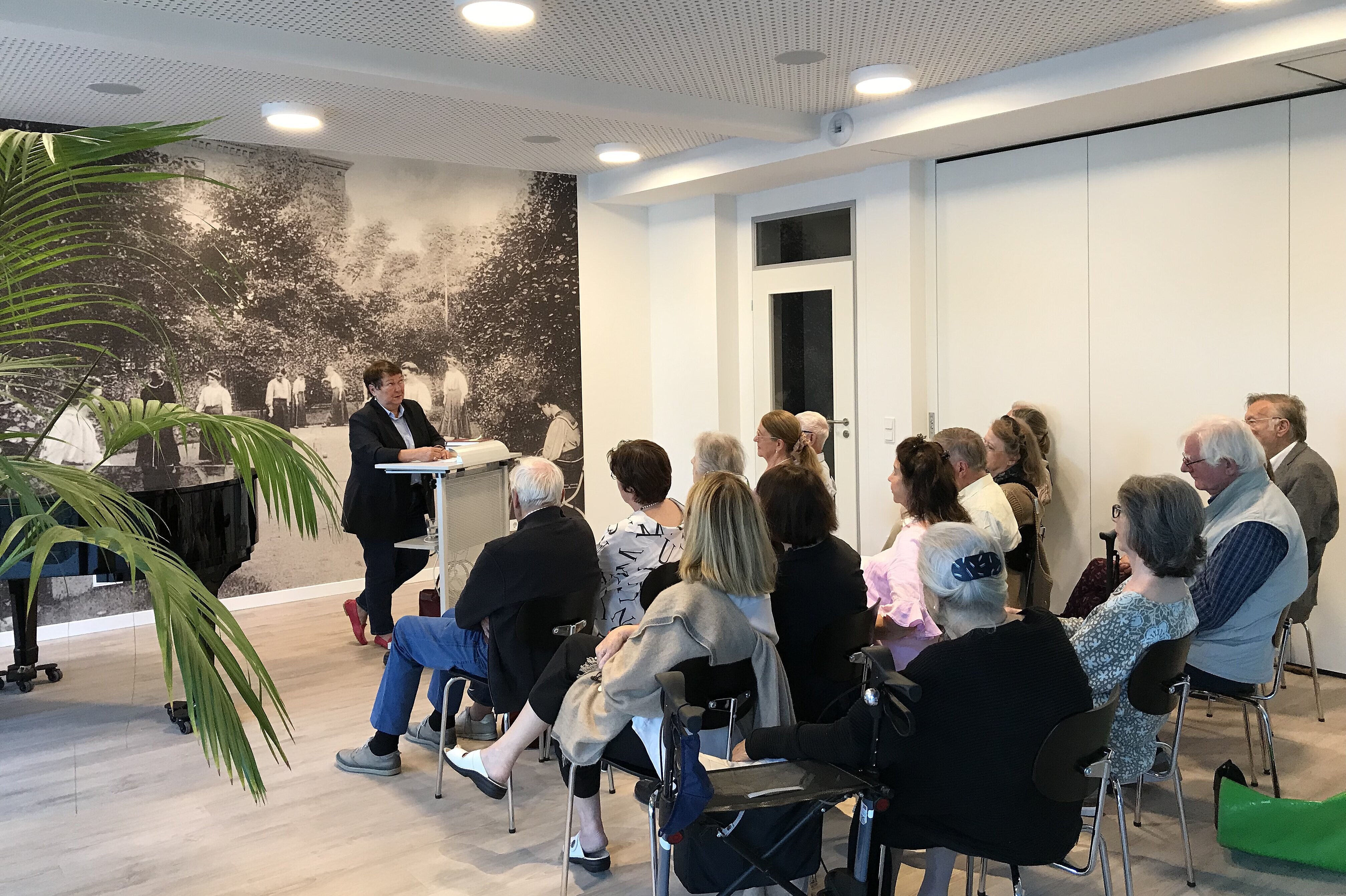 Foto: Zuschauer_innen hören einer Rednerin zu